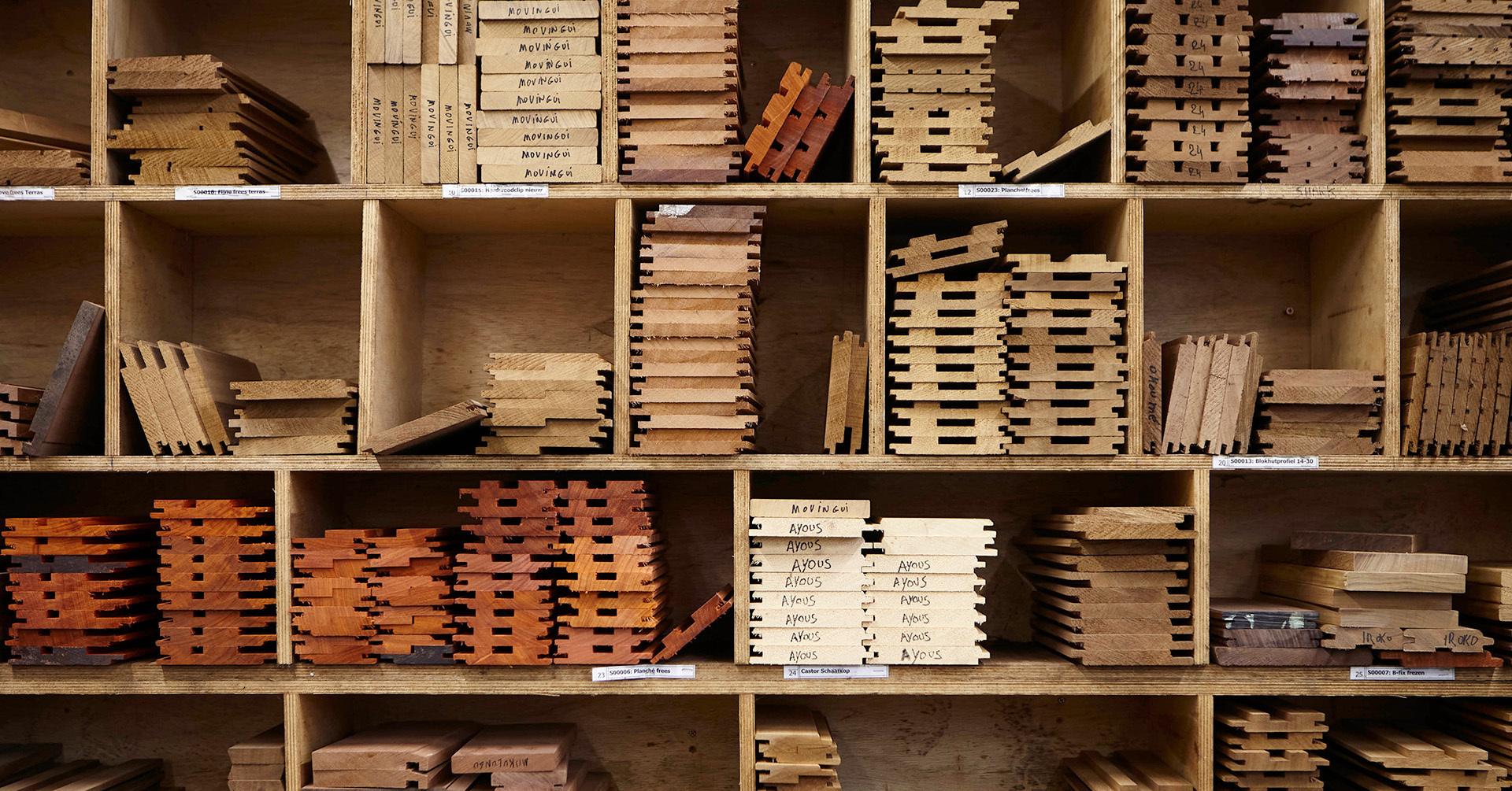 sfeerbeeld van een muur waar een voorraad hout gesorteerd en opgeslagen ligt