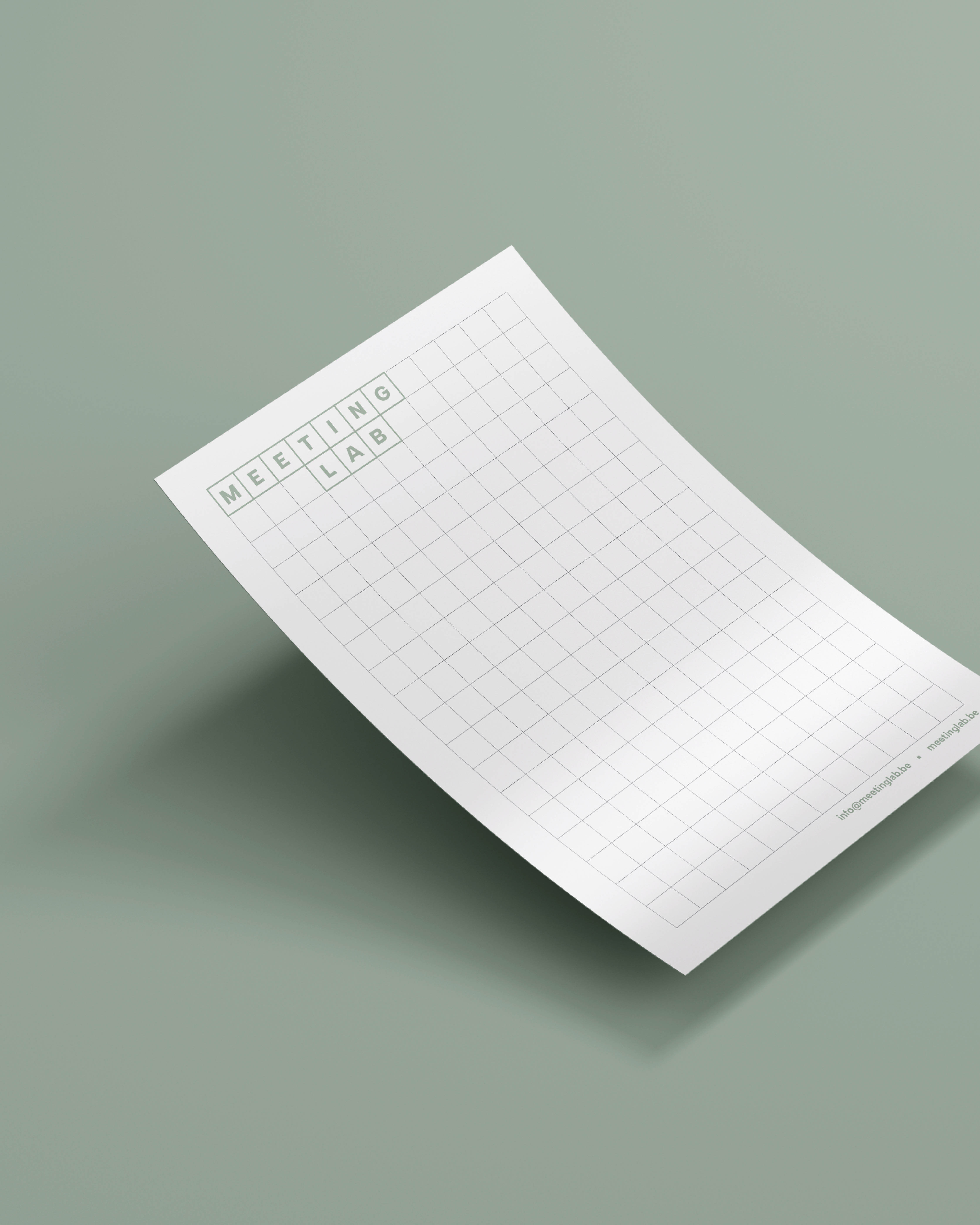Wit geruit notitieblad met het logo van Meeting Lab ligt schuin op een groene achtergrond.